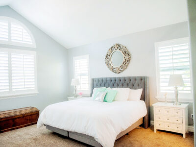 White Composite shutters with Tilt bar in a bedroom with an arched window