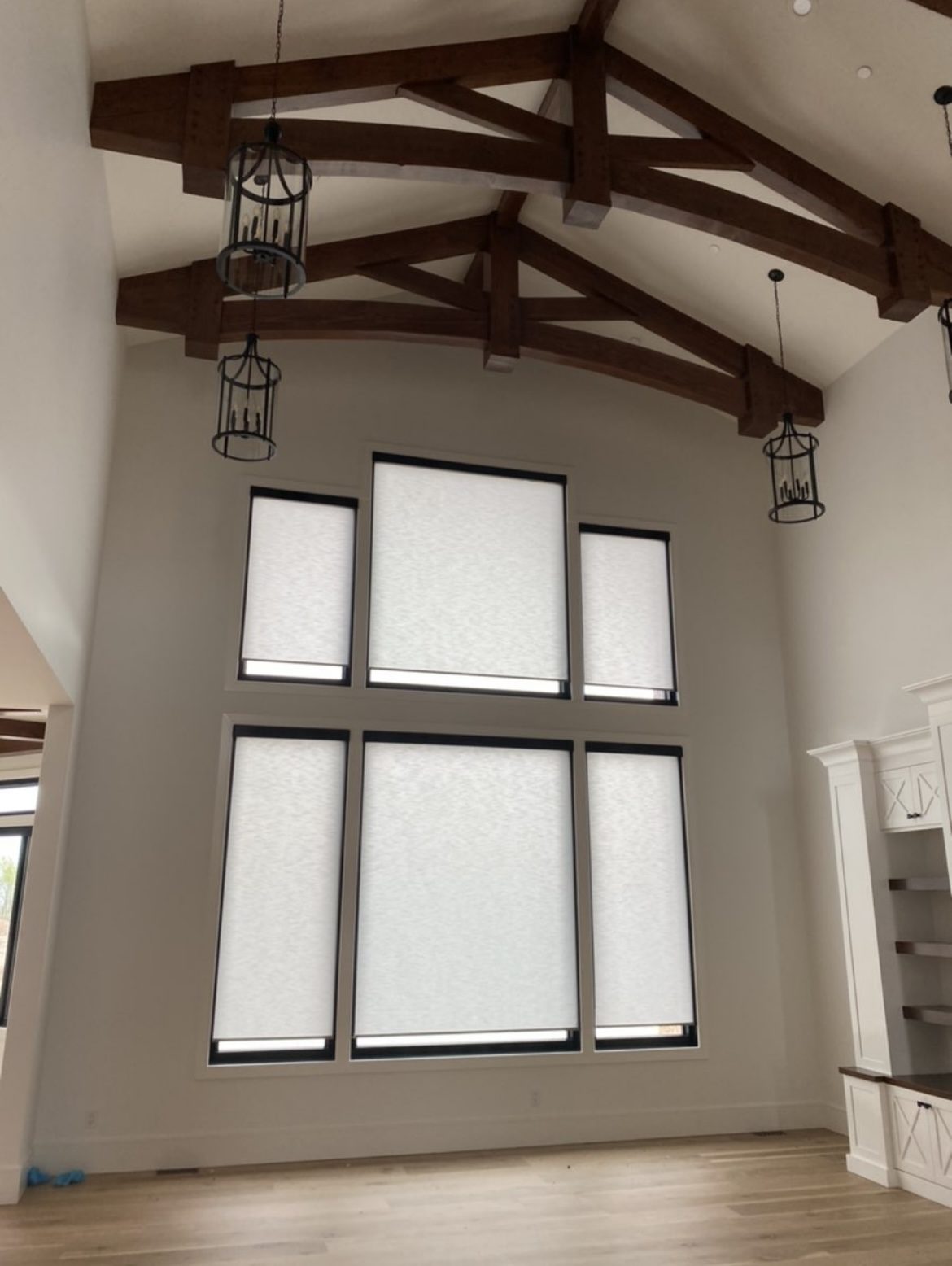 white light filtering rollershades with black top treatment in a living area with vaulted ceilings